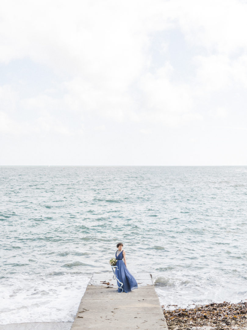Une mariée au bord de l'eau - Portrait d'une mariée en robe bleue - La mariée aux pieds nus - Photo : Capyture